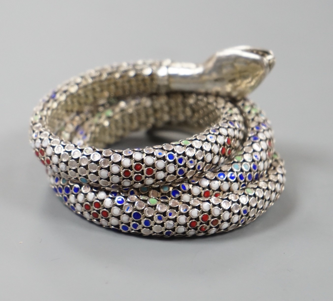 A continental 935 white metal and polychrome enamel set coiled serpent bangle.